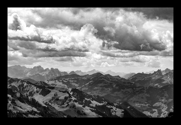 Berglandschaft vom Stockhorn aus gesehen. Bis zum Horizont sieht man nix anderes als Berge - vorne dunkel, hinten immer heller und obendrüber Gewölk. Natürlich schwarzweiss.